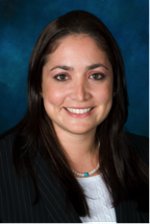 Portrait of a smiling woman in a black pinstripe suit on a blue background